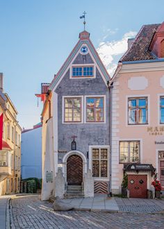 a cobblestone street lined with old buildings in the middle of an urban area