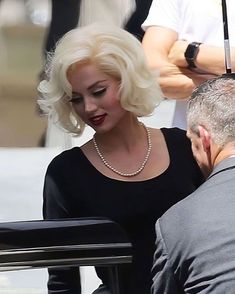 lady with blonde hair and pearls on set