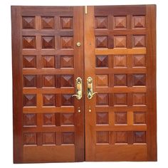 two wooden doors with decorative designs on each door and one has a gold handle in the middle