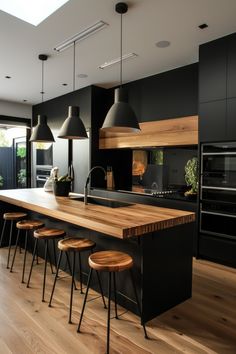 an open kitchen with black cabinets and wooden counter tops, stools at the island