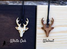 two necklaces with deer heads on them sitting next to each other