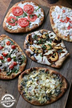 four pizzas with different toppings sitting on a cutting board