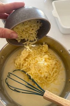 someone is mixing cheese in a pan on the stove