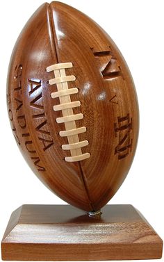 a wooden football trophy on top of a wood base