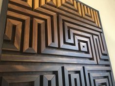 an art piece made out of wood with geometric designs on the sides and bottom part