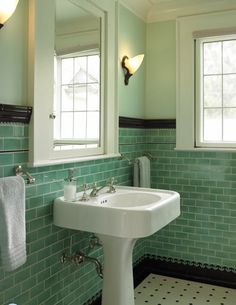 a white sink sitting under two mirrors in a bathroom