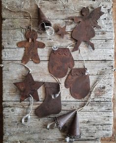 an assortment of rusty metal ornaments on a wooden table with twine and bells hanging from them