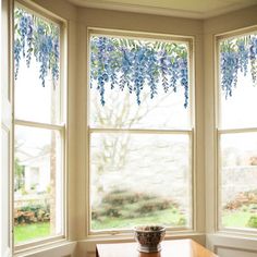 a room with three windows and a vase on the window sill