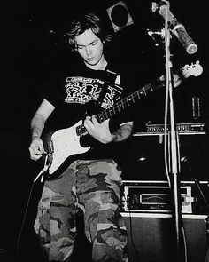 a young man playing an electric guitar on stage