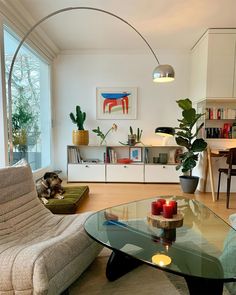 a living room filled with furniture and a glass table in front of a large window