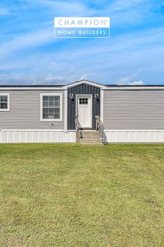 a mobile home with the words champion on it and stairs leading up to the front door