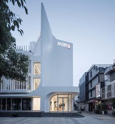 a white building with stairs leading up to it's entrance and the word more written on its side