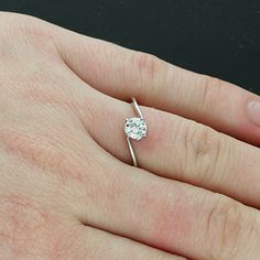 a person's hand with a diamond ring on it