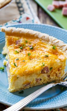 a piece of quiche on a blue plate with a fork