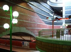 an empty subway station with lights on the ceiling and no people in the area around it