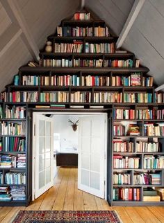 a room filled with lots of books on top of a book shelf next to a doorway