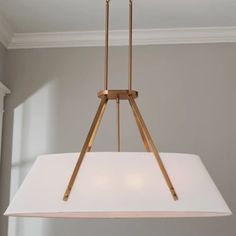 a light fixture hanging from the ceiling in a room with white walls and flooring