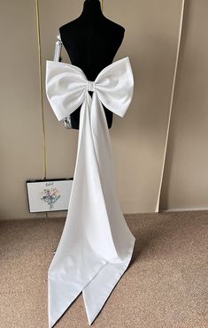 a dress form with a white bow on it