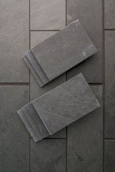 four pieces of slate sitting on top of a tile floor