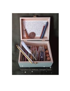 an open wooden box with writing supplies in it