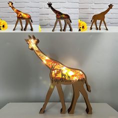 three giraffes are standing in front of a white brick wall with yellow flowers