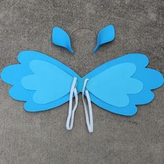 a paper butterfly cut out to look like it is sitting on the ground with scissors