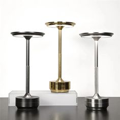 three different types of lamps sitting on top of a table next to eachother