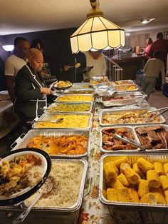 many trays of food are lined up on a table