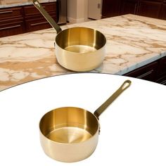 two gold pans sitting on top of a white table next to a marble counter