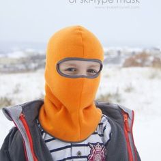 a young boy wearing an orange ski mask in the snow with text overlay that reads diy balaclava or ski - type mask