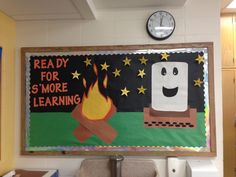 a bulletin board with a fire and marshmallows on it in a classroom