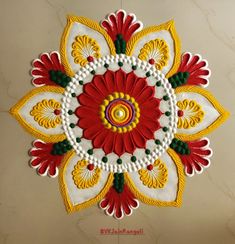 an intricately decorated wall hanging with red, yellow and white flowers