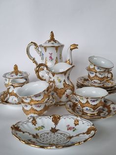 an antique porcelain tea set with gold trimmings