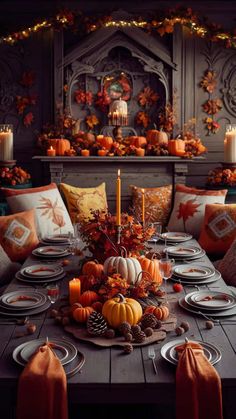 a dining room table set for thanksgiving dinner with pumpkins, candles and other decorations