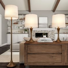 a living room filled with furniture and two lamps on top of a wooden table in front of a fireplace