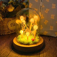 a glass dome with candles in it on a table