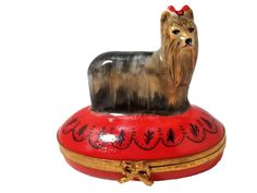 a dog figurine sitting on top of a red box