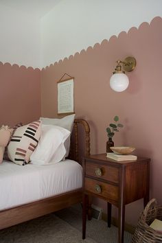 a bedroom with pink walls and white bedding