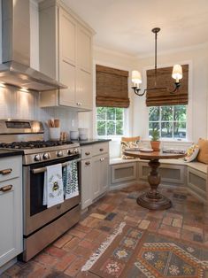 a kitchen with an oven, stove and table in it