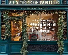 the front window of a store decorated with garlands and christmas lights in french language