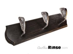 three metal handles on a wooden stand