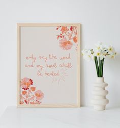 a white vase with flowers next to a framed print on the wall that says, only many the world and my soul shall be headed