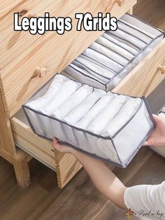 a person is holding a drawer full of folded white sheets and linens with the words leggings 7 grids on it