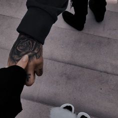 a person with a rose tattoo on their left hand and foot next to someone's feet