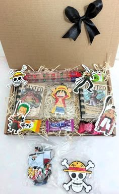 an open box with pirate themed items and a black bow on the top of it