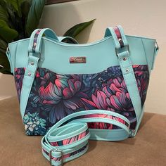 This might be my favorite one yet.  It is a good mid-size purse with 2 exterior slip pockets, an interior split slip pocket and zip pocket.   It also includes a sunglasses compartment.  You can use as an over the shoulder bag or add the custom crossbody strap. - Teal/Dark Blue/Coral Faux Leather/Vinyl  - Interior pocket for sunglasses - Interior split slip pocket for your phone or any other quick grab essentials - Interior side zipper pocket for safe storage - Custom shoulder and crossbody straps Size:  9"h X 12"w base/15"w top X 6"d Pattern:  Hiraetha Handbag by Lavender & Twine Carpet Bags, Vinyl Interior, Modern Handbag, Over The Shoulder Bag, Teal Coral, Over The Shoulder Bags, Carpet Bag, Accessories Style, Blue Coral