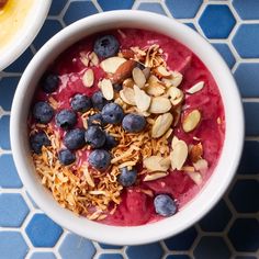 two bowls filled with fruit and nuts on top of a blue tile floor next to a bowl of oatmeal