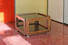 a small wooden table sitting on top of a red floor