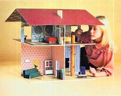 a doll house is shown with a woman and child looking at the contents in it