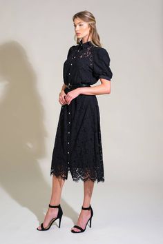 Indulge in the ultimate fashion statement with this stunning black woven lace dress. Pair it with cowboy boots to effortlessly embody the Western/Gothic trend. The dress boasts a beautifully detailed woven lace design, complete with a classic shirt collar, button down front, short puff sleeves, and a striking contrasting belt. Details: 65% Cotton 35% Nylon Contrast : 100% Polyester Lining : 100% Polyester Size & Fit - Model is 5`8" And Wearing Size Small Approx. Length: 47" Western Gothic, Lace Shirt Dress, Lace Black Dress, Grace And Lace, Short Puff Sleeve, Top And Pants Set, Jumpsuits And Romper, Swimsuit Dress, Lace Dress Black